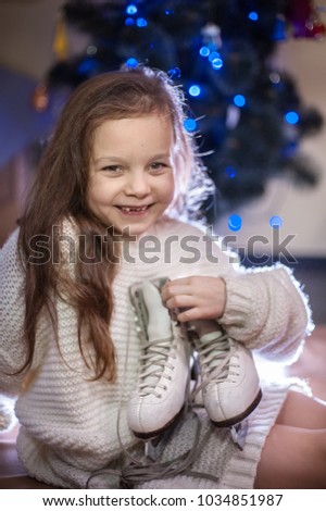 cute little girl holding her white ice skaters
