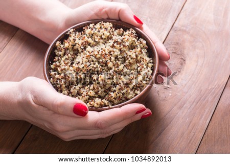 Healthy cooked quinoa in woman hand . Superfood background