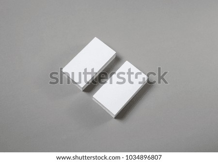 Stacks of blank business cards on grey paper background.