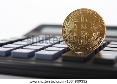 Bitcoin on the keyboard of the calculator. Shallow depth of field. A visual representation of digital cryptocurrencies. Bitcoin are fully dematerialized and decentralized electronic currencies