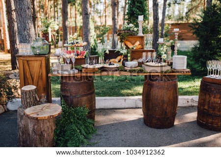 Dinner table with snacks and lemonade stands on the lawn outside Royalty-Free Stock Photo #1034912362