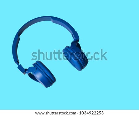 Headphones. Headphones on blue background. Headphones for music sound. Isolated on blue background. Blue headphones on blue background. Music concept. Royalty-Free Stock Photo #1034922253