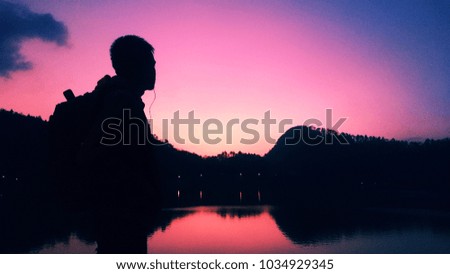 Silhouette of man at a lake