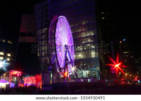 Luminous Ferris wheel during Montreal vivid Festival of Lights. Colorful illuminated silhouettes in the night. Winter festival of arts. Outdoor family activities. Entertainment District.