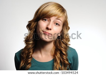 Slightly Smiling Teenage Girl. Teenage girl making a slight smile with a tilted head as if she is bored. Note: not isolated.