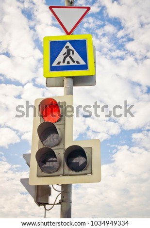 traffic light and road signs against the blue sky