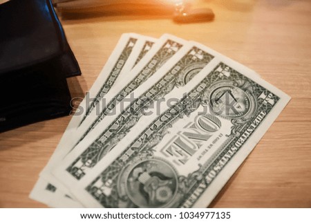 dollar for pay or buy product put on wooden table,Money for everyday shopping and Investment for saving concept