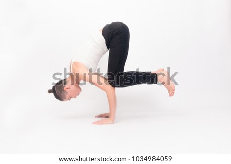 fitness, sport, training and lifestyle concept - Young woman doing yoga exercise. Portrait of young beautiful girl in white sportswear doing yoga practice.Woman doing stretching exercise