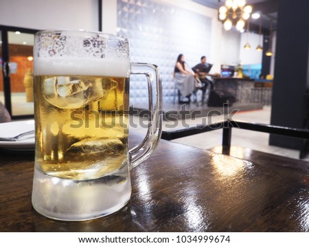 Beer mug in a restaurant with Blurred the band is playing.