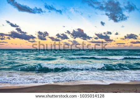Picture of the sunset at Miami Beach, showing the sea, a cloudy and colorful sky, and ships at the background