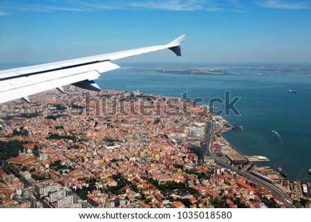 Visit Portugal! The historical center of Lisbon under the plane wing. Roofs of houses and old quarters.