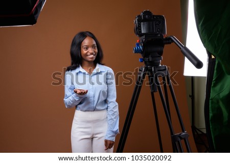 Studio shot of young beautiful African Zulu businesswoman wearing blue shirt against brown background
