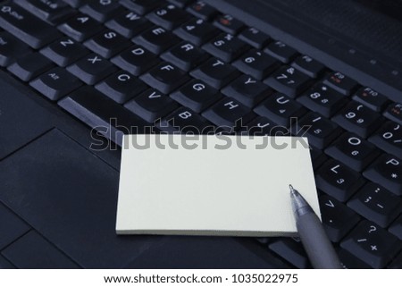 Blank paper with pen on laptop keyboard. Selected focus.
