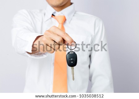 Businessman holding the car key, isolated background