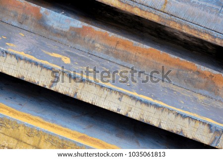 Diagonal edge close up showing large steel industrial rolled plating panels used in manufacturing and construction work. Colorful weathering on metal supplies background. 