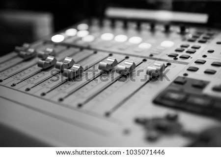 Sound recording studio mixing desk. Music mixer control panel. Closeup. Selective focus. Black and White image Royalty-Free Stock Photo #1035071446