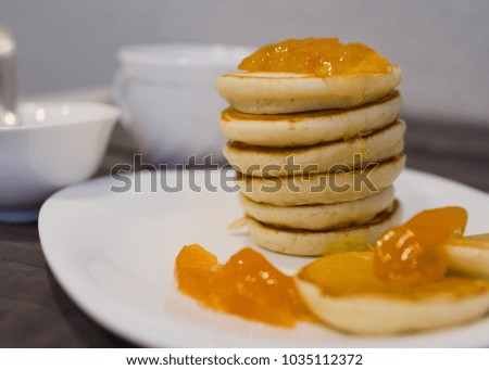 Homemade fluffy pancakes with jam on white plate for breakfast