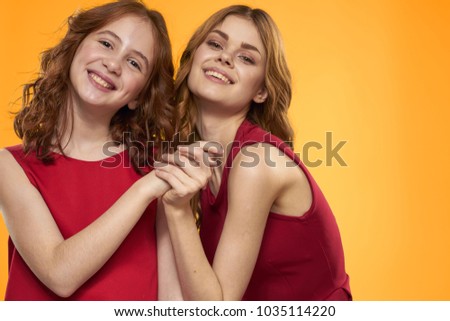  girls smiling holding hands on a yellow background, emotions                              
