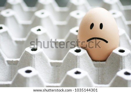 Sad face on eggs in egg box background. Bad day feeling concept Royalty-Free Stock Photo #1035144301