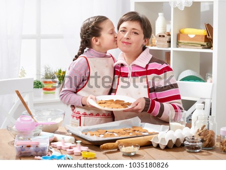 Mother and daughter baking cookies, home kitchen interior, healthy food concept