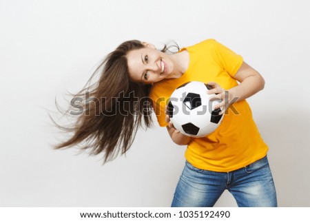 Beautiful European young woman, football fan or player in yellow uniform holding soccer ball fluttering hair isolated on white background. Sport, play football, health, healthy lifestyle concept