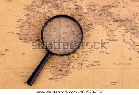 Magnifying glass on vintage map. Travel and adventure Concept.