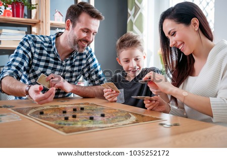 Happy family playing board game at home, happiness concept Royalty-Free Stock Photo #1035252172