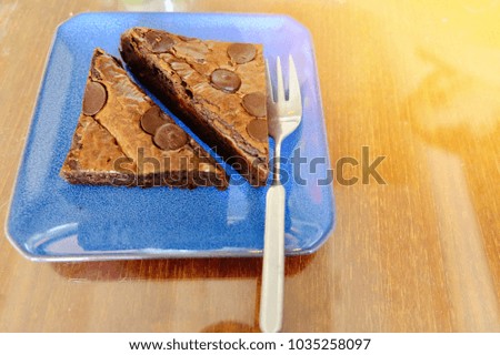 Blur picture of two piece of brownies and small fork on blue plate with space for your text and design. Concept be used for present bakery in coffee shop and bakery shop business.