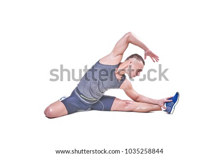 Handsome man performs stretching in sportswear isolated on white background