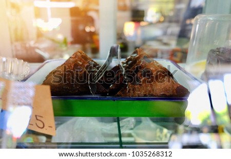 Blur picture of seven piece of brownies and small tongs on white plate in mirror showcase with space for your text and design.Concept be used for present bakery in coffee shop and bakery shop business