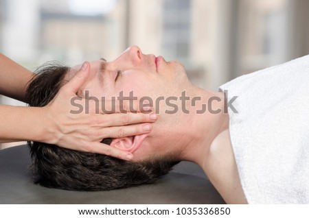 Physiotherapist, chiropractor assessing the muscles on a jaw. Osteopathy