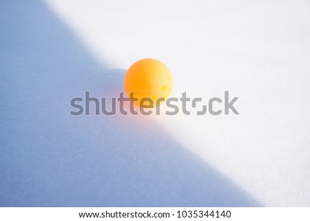 Ping pong ball on the snow. Table tennis, also known as ping pong, is a sport in which two or four players hit a lightweight ball back and forth across a table using small bats.