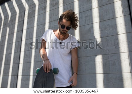 Stylish man in sunglasses with skateboard.