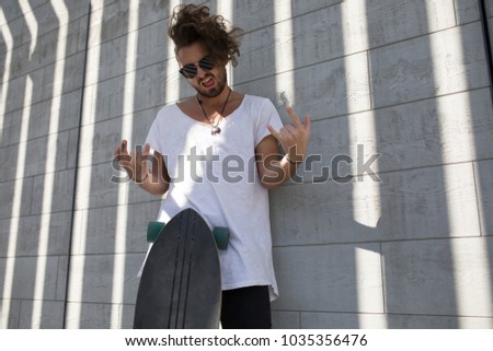 Stylish man in sunglasses with skateboard.