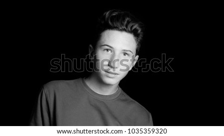 young guy portrait on black background - black and white photo