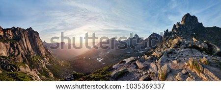 Panoramic photo of the spring mountain valley natural Park Ergaki, Russia. Fabulous sunrise and sunset in the mountains, amazing nature, spring in the mountains. Travel and hike Royalty-Free Stock Photo #1035369337
