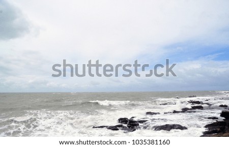 the view from the shore of the raging ocean during a storm, in the Spanish city of Cadiz, large waves crash on rocks and stones