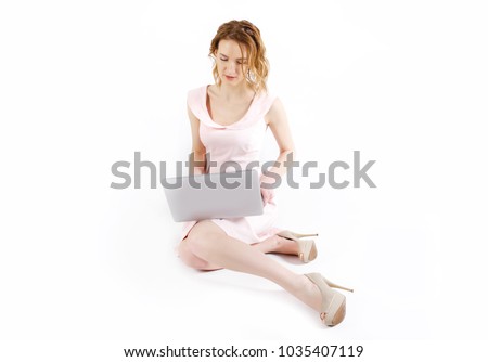 young woman sitting on floor with laptop on white