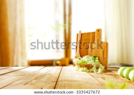 Table background in kitchen with big blurred window and easter eggs on top. Free space for your decoration. 