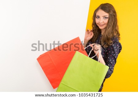 Attractive woman with banner and shopping bags