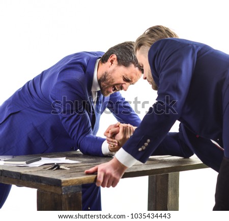 Businessmen fighting for leadership. Business rivalry concept. Men in suit or businessmen with painful faces compete in armwrestling on table on white background. Confrontation of business leaders.