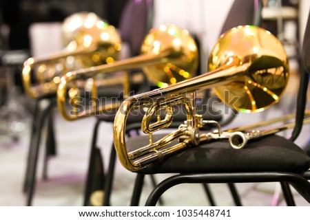 Trombones lying on the chairs in the orchestra Royalty-Free Stock Photo #1035448741