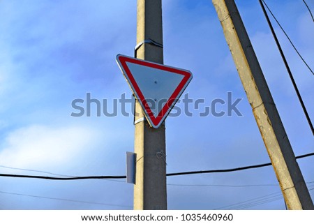 Road sign give way hanging on the concrete pillar