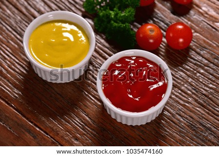 Bowls of mustard sauce and ketchup