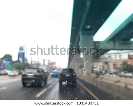 Blurred image, raindrop on the windshield, traffic in the city on a rainy day, car windshield view, colorful bokeh.