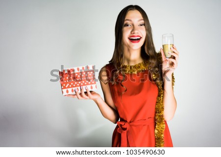 woman on a gray background celebrates the coming of the new year with champagne in her hands