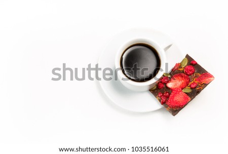 cup of coffee and hand-made chocolate with dried strawberries and berries on a white background