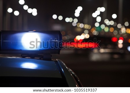 Police car at night, lights flashing in Seoul