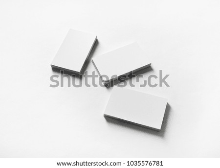Mockup of blank business cards on white paper background.