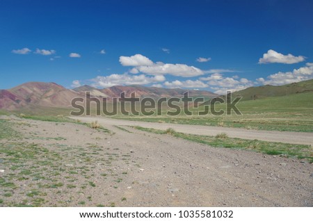 Mongolian Altai. Mountain pass. Dirt road. Scenic valley and multicolor mountains. Nature and travel. Mongolia, Bayan-Olgii Province